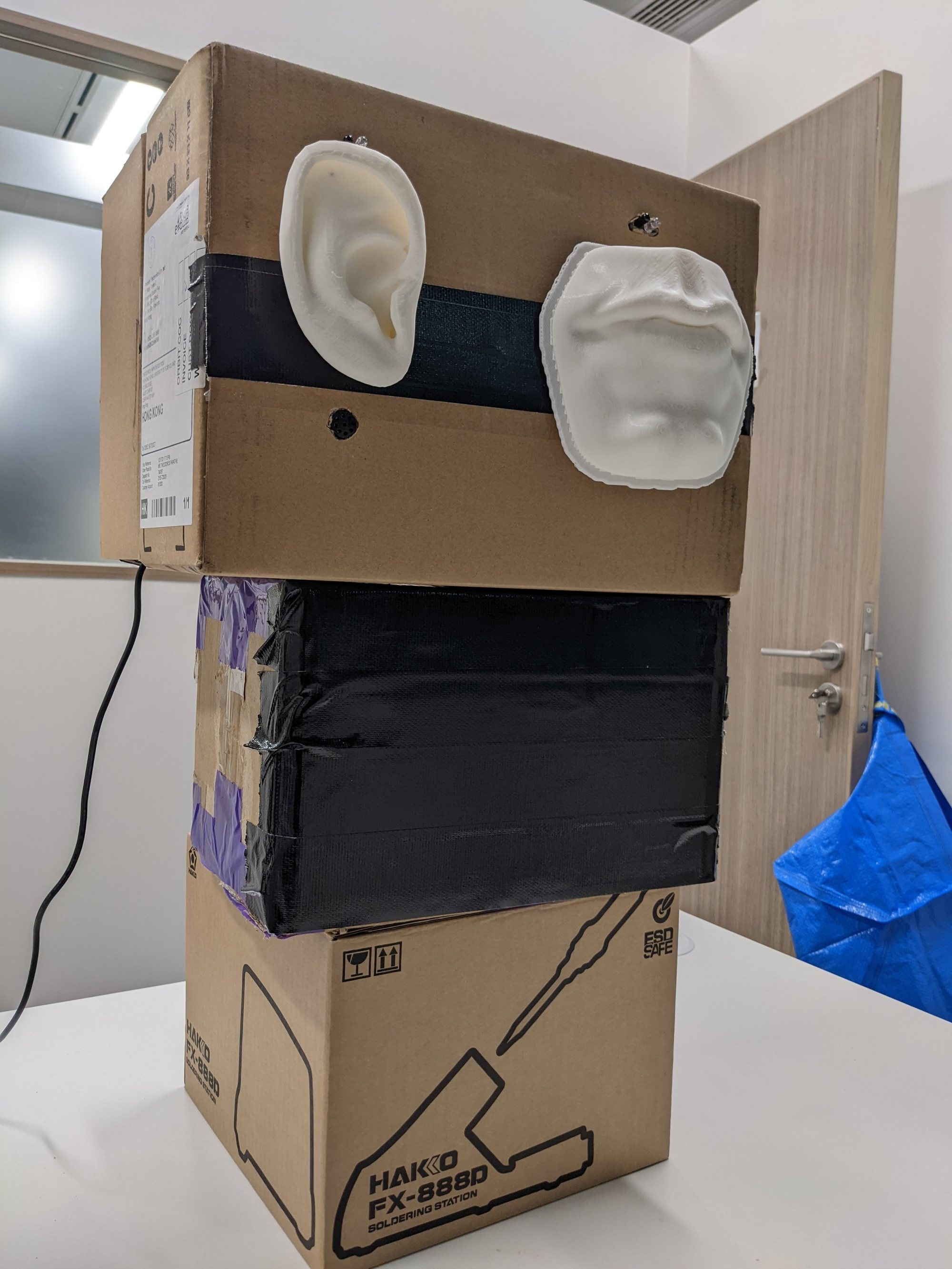 Cardboard prototype with ear and mouth sculptures
