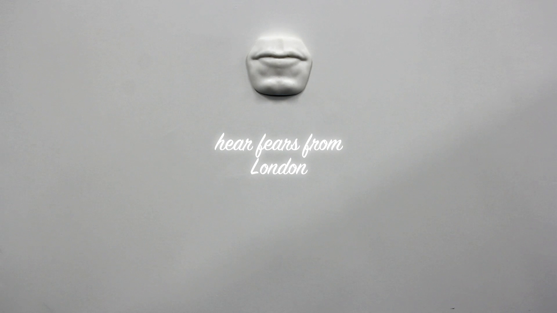 Sculptural mouth on a wall with the text 'hear fears from London'