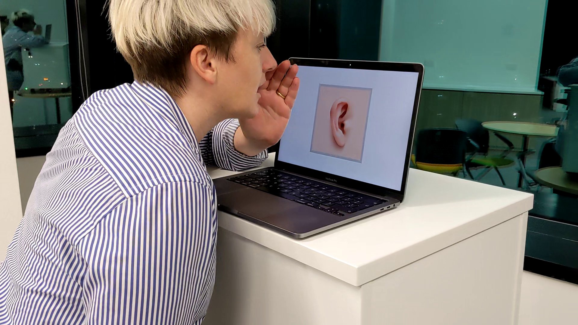 Testing Fear Exchange: a person whispering to an ear shown on a laptop screen