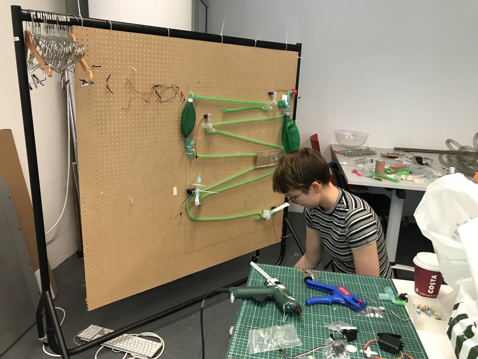 Building a marble run from medical tubing on a pegboard