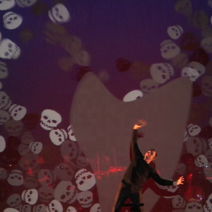 A Christmas Carol: actor on stage among projected skulls