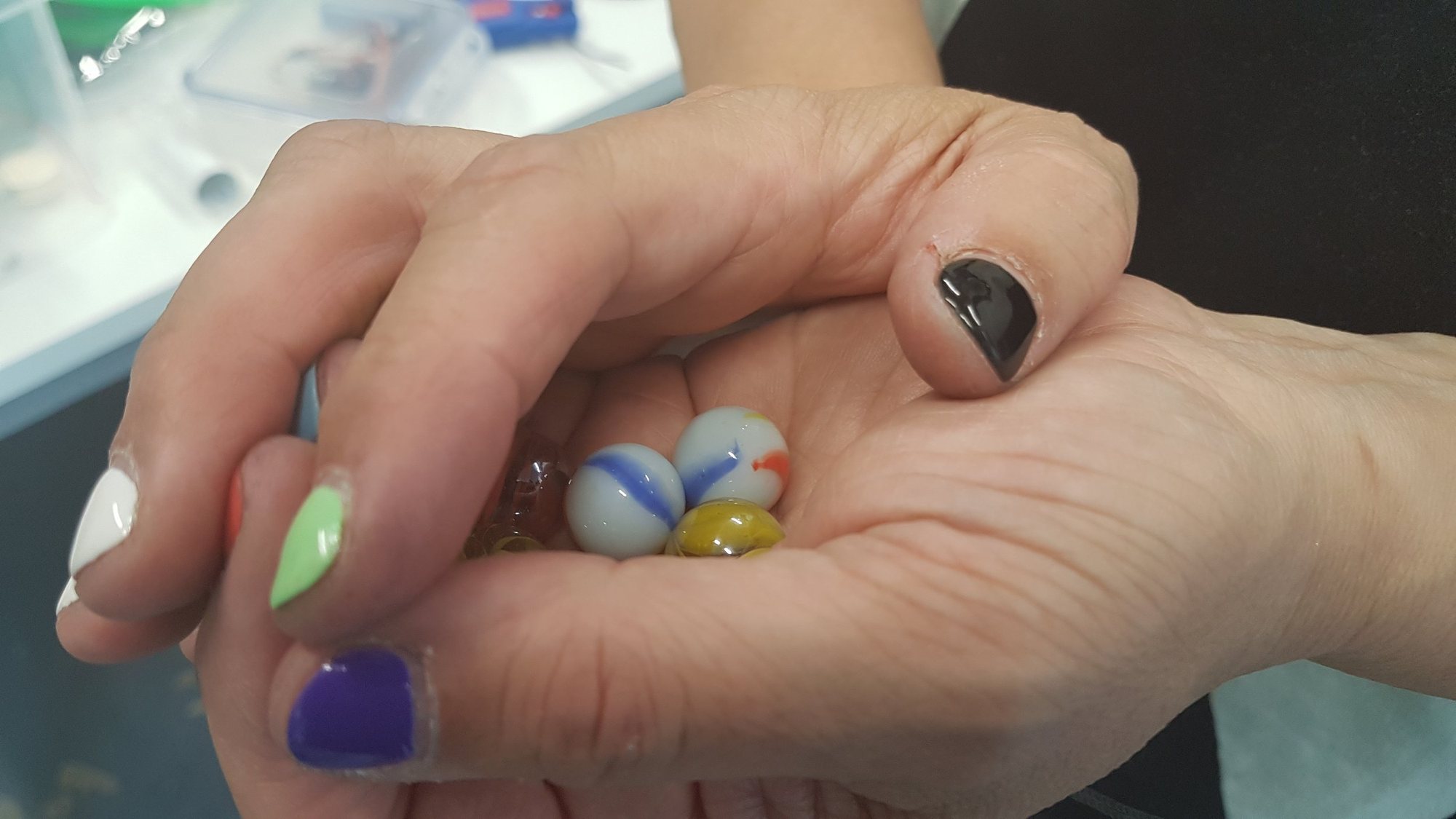 Hand holding marbles used in The Long Run
